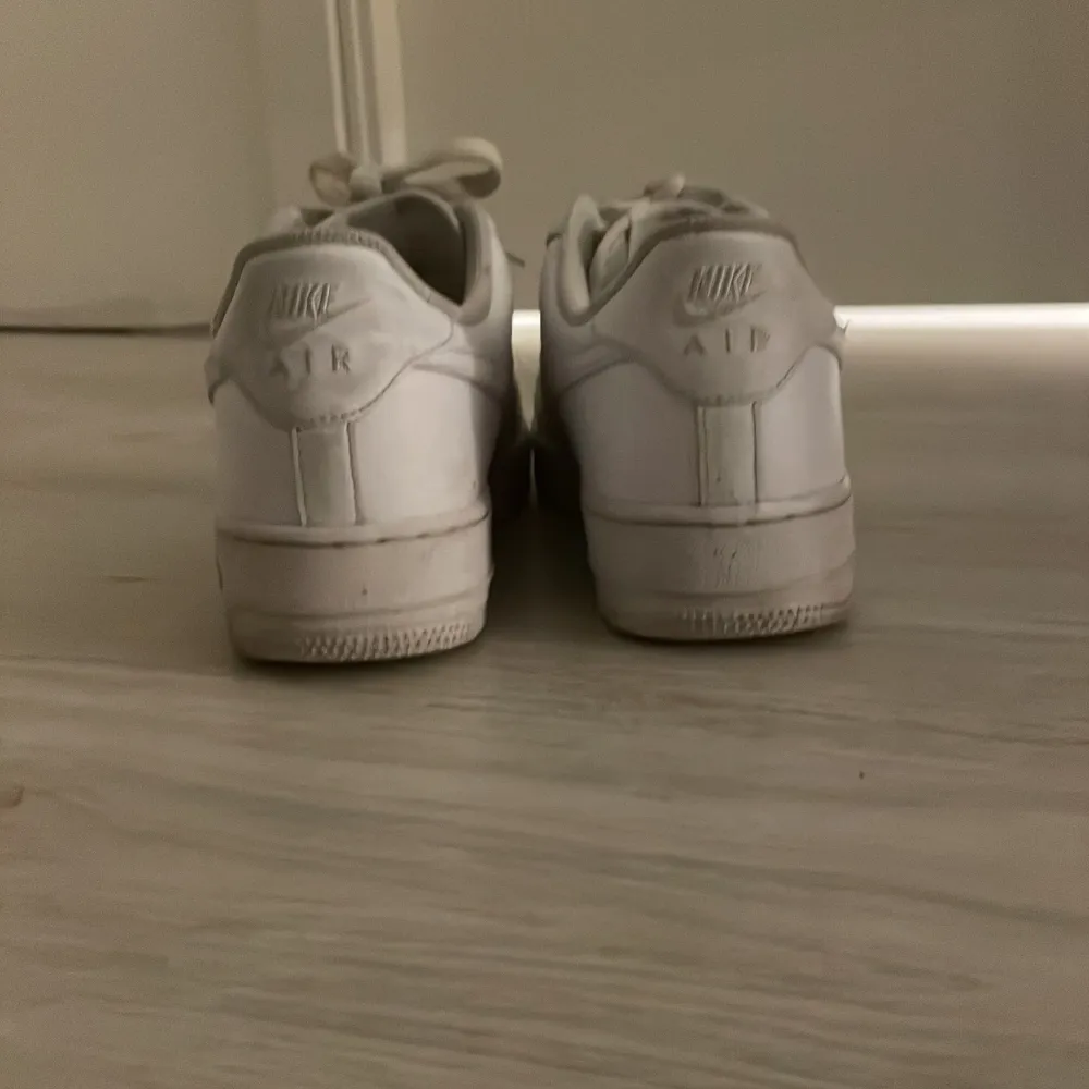 Säljer ett par vita Nike Air Force sneakers i bra skick. De har klassisk snörning och är perfekta för vardagsbruk. Skorna har lite slitage men är fortfarande snygga och bekväma. Perfekta för både vår och sommar! Storlek40. Skorna kommer tvättas innan leverans!. Skor.