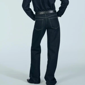 Mörkblå jeans - Säljer ett par snygga, mid waisted mörkblå jeans. De har en klassisk femficksdesign och raka ben som ger en tidlös look. Slutsålda på Zaras hemsida pga trendig tvätt och modell. Jag är 178 cm och bär vanligtvis 36/38 i byxor! Endast använda ett fåtal gånger.