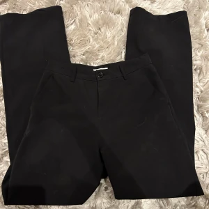 Svarta byxor från Lindex - Säljer ett par stilrena svarta kostymbyxor från Lindex i storlek 164/13-14y . De har en klassisk design med knapp och dragkedja framtill. Säljer för 150kr, bra skick 