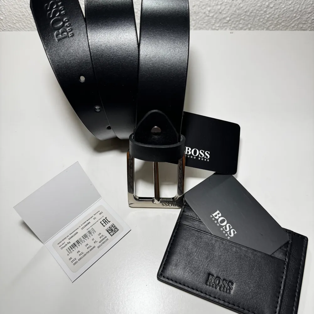 New Hugo Boss Black Orignal leather Belt with tags. *- Aailable for following waist sizes 34 Inches 36 Inches 38 Inches * New with Tags. * Dispatch within 1 Working day 个Note Please mention your waist size in instructions or Message after you have placed order for the belt.                                  NEW BOSS Black Original Leather Card Holder With 09x Card Slots.  04 slots on each side and 01 in the middle on top. * New with Tags * Will be a perfect Christmas present. Accessoarer.