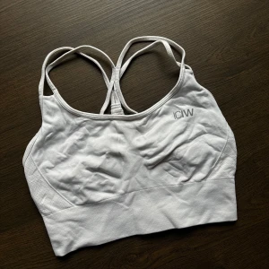Vit sport-bh från ICANIWILL - Säljer en vit sport-bh från ICANIWILL i mycket bra skick. Den har korsade axelband och en bred resår under bysten för extra stöd. Perfekt för träning och ger en bekväm passform. Materialet är mjukt och stretchigt.