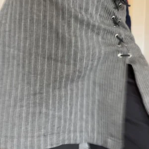 Grå randig kjol med snörning - Säljer en superfin grå kjol med smala vita ränder och svart snörning. Kommer tyvärr inte till användning längre🩷🩷🩷 