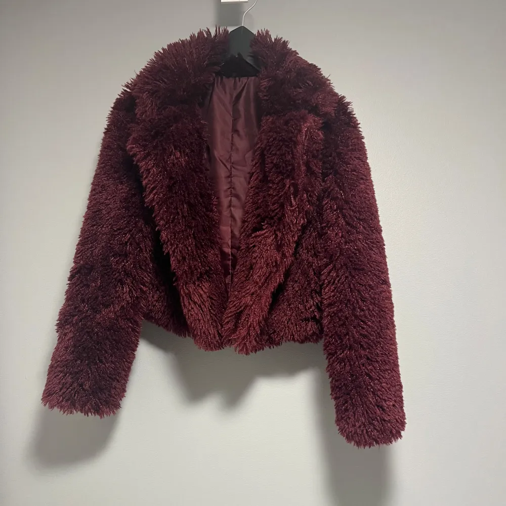 Säljer en supermjuk och fluffig röd faux fur jacka från Dressy Elise. Perfekt för att hålla sig varm och stilren under kyliga dagar. Jackan har en lyxig känsla med sin djupa röda färg och långa ärmar. Passar perfekt för både vardag och festliga tillfällen. 🧥✨lite kort vid midjan dock men fortfarande skit snygg. Tveka inte om att höra av dig!❤️. Jackor.