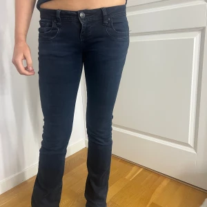 Mörkblå jeansbyxor - Snygga mörkblå jeans med låg midja och flare passform. Använda väldigt få gånger!