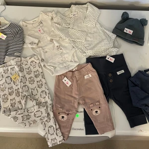 Klädpaket Newbie  - Nio plagg Söta barnbyxor med ugglemönster i grått och vitt och pyjamasen är storlek 80 de övriga har storlek 62-68.