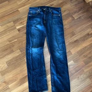 Levi's 501 jeans nya - Klassiska Levi's 501 jeans i en snygg mörkblå färg. De har en rak passform och är tillverkade i slitstarkt denim. Perfekta för en tidlös stil med knappgylf och fem fickor. Jeansen är helt nya då de inte passade mig.