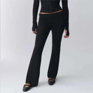 Svarta byxor med bootcut - Snygga svarta byxor med bootcut-stil och låg midja. Perfekta för en stilren look. Tillverkade i ett mjukt och stretchigt material för extra komfort.