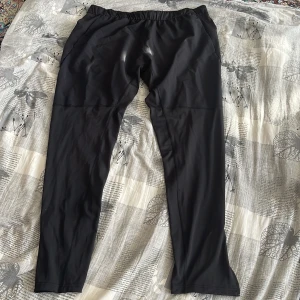 Svarta träningsbyxor från SOC - Säljer ett par svarta träningsbyxor med elastisk midja. Perfekta för gymmet eller löprundan. De är tillverkade i ett lätt och stretchigt material som ger bra rörelsefrihet.