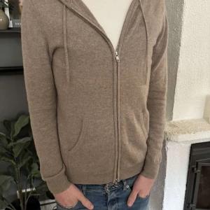 Beige kashmir hoodie från John Henric - Säljer en stilren beige hoodie i mjuk kashmir från John Henric. Tröjan har dragkedja framtill och en bekväm huva med snören. Bra skick och inga speciella defekter. Nypris: 2499:- 🤩