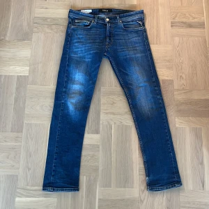 Blå jeans från Replay - Snygga blå jeans från Replay med en klassisk femficksdesign. De har en lätt slitning på framsidan och en rak passform. Perfekta för en avslappnad stil.
