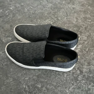 Michael kors skor - Slip on skor, som ja använt ett fåtal gånger. Dom är i väldigt bra skick, bara små detaljer på smuts som säkert går att putsa bort. Priset går att diskutera vid snabb köp!