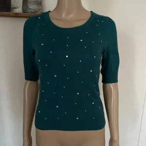 Stickad tröja med stenar - Några stenar borta