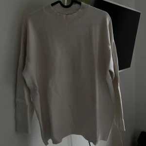 Beige tröja från MNG - Säljer en stilren beige tröja från mango. Den är långärmad och har en klassisk rund halsringning med ribbade kanter. Obs INGEN fläck på första bilden! 