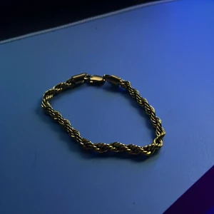 Guldarmband med tvinnad design - Elegant guldarmband med en tvinnad design som ger en stilren och klassisk look. Armbandet har en säker låsmekanism och passar perfekt för att ge en touch av lyx till din stil.