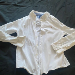 Vit skjorta från Polo Ralph Lauren - Grymt skick, Pris går att diskutera vid snabb affär. Klassisk vit skjorta från Polo Ralph Lauren med broderad logotyp på bröstet. S/Xs