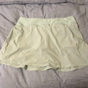 Lululemon träningskjol - Säljer en ljus kjol från Lululemon. Kjolen har en sportig design med en bekväm passform. Den är tillverkad i ett lätt och stretchigt material som ger rörelsefrihet. Ficka bak och inbyggda shorts. Fint skick. Nypris 599 kr.