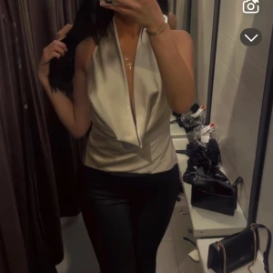 Beige halterneck topp - Snygg beige halterneck topp från Zara med öppen rygg och knytning i ryggen. Perfekt för en stilren look.