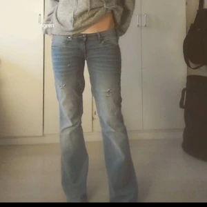 Blå lågmidjade bootcut jeans - Snygga blå bootcut jeans med slitna detaljer på låren. De är väldigt lågmidjade då jag har sytt ner de till lågmidjade. Skulle säga att de är i storlek S/M. Jag säljer då de är lite för stora för mig. Jag är 1,65 lång och sitter bra i längden på mig. Skriv ifall ni har några frågor🩷