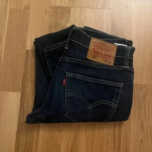Mörkblå jeans från Levi's 511 - Snygga mörkblå jeans från Levi's med klassisk design och fem fickor. Perfekta för en stilren look. Märkeslappen syns tydligt på baksidan.            Storlek:                                                                                W:29 L:32