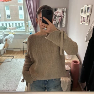 Beige stickad tröja med knytband - Säljer en mysig och så snygg beige stickad tröja från Mango!🙌 Tröjan säljs inte längre och är använd ett fåtal gånger men har inga synliga tecken på användning.