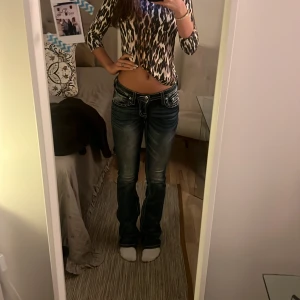 Blå jeans från Miss Me - Pris kan diskuteras. Knappt använda snygga blå jeans från Miss Me med låg midja och bootcut-stil. De har dekorativa detaljer på bakfickorna och en klassisk femficksdesign. Perfekta för en trendig look. Midjemått är 74 och innerbenslängden är cirka 83. Jag är 164 och de är lite långa på mig