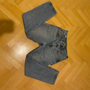 Blå jeans från Levi's - Klassiska blå jeans från Levi's med rak passform och fem fickor. De har en knappgylf och är tillverkade i slitstarkt denim. Perfekta för en avslappnad stil. Pris kan diskuteras 
