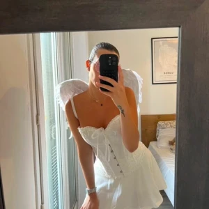 Vit korsett med spetsdetaljer - Elegant vit korsett med vackra spetsdetaljer och snörning framtill. Passar superbra till utklädnad! Endast använd en gång.✨