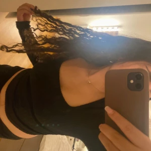 Svart långärmad topp - Snygg svart långärmad topp med en tight passform. Perfekt för en stilren look. Toppen är enkel och mångsidig, vilket gör den lätt att matcha med olika outfits.