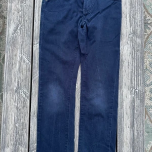 Mörkblå Levi's 511 Slim jeans - Snygga mörkblå Levi's 511 Slim jeans med klassisk design och fem fickor. Perfekta för en stilren look. De har en knapp och dragkedja framtill.