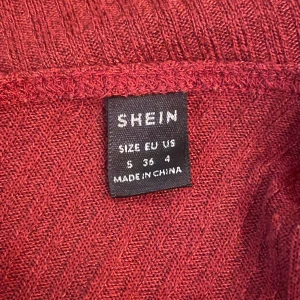 Röd ribbad tröja från Shein - Snygg röd ribbad tröja från Shein i storlek S. Perfekt för kyligare dagar med sin långa ärm och mjuka material. Enkelt att matcha med olika outfits för en stilren look.