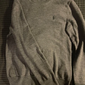Grå tröja från Polo Ralph Lauren - Säljer en stilren grå merino wool tröja från Polo Ralph Lauren. Tröjan har en broderad logotyp på bröstet. Storleken på tröjan är XS men står S i tröjan (lite minskad men bäst för XS men kan passa S också). Skick 10/10. Nytvättad innan postad. Nypris: 2400kr