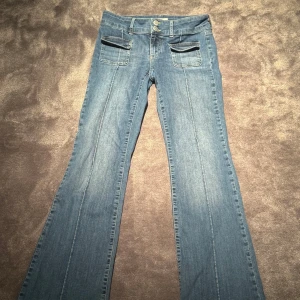 Blå jeansbyxor från NELLY - Snygga blå jeansbyxor från NELLY med bootcut och Låg midja💙 Storlek 38, passar 