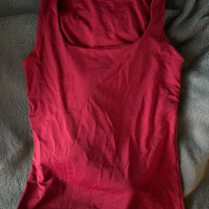 Röd linnetopp från Zara - Säljer en stilren röd linnetopp från Zara. Toppen är ärmlös och har en klassisk rund halsringning. Perfekt för varma dagar eller som ett lager under en jacka.