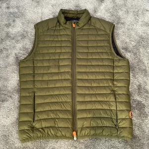 Olivgrön dunväst från Save the Duck - Säljer en olivgrön dunväst från Save the Duck💯🍾 Västen är quiltad och har en dragkedja framtill. Den är tillverkad av syntetiskt dun, vilket gör den både andningsbar och vattentät❌💦Perfekt för dig som vill ha ett djurvänligt alternativ🍷💨 Nypriset på denna snygga väst ligger på 1699kr och mitt pris är endast 719kr. Diskuterbart pris😁