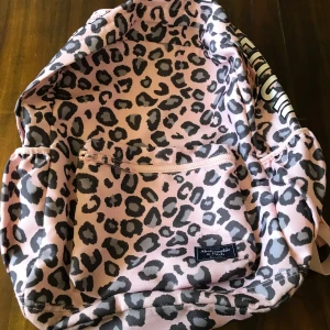 Rosa leopardmönstrad ryggsäck från Abercrombie - Säljer en cool rosa ryggsäck med leopardmönster från Abercrombie. Ryggsäcken har en praktisk dragkedja och justerbara axelremmar. Perfekt för att sticka ut i mängden med stil! 🐆