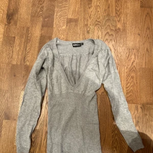 Grå v-ringad tröja från EMO.nite - Säljer en stilren grå tröja från EMO.nite med v-ringad design. Tröjan har långa ärmar och är tillverkad i ett mjukt material som ger en bekväm passform. Perfekt för en avslappnad look.