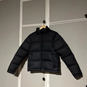 Svart dunjacka från Everest - Aldrig använd, endast testat (legat undan länge, där med har det blivit en liten liten fläck på baksidan(se sista bild). Vet ej om den går bort, annars fyller den sin funktion helt. 