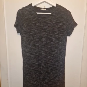 T-shirtklänning - Snygg och enkel gråmelerad klänning från C&A. Idealisk för vardagsbruk, ett måste i garderoben för en stilren look!