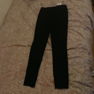 Svarta kostymbyxor från Vila - Snygga svarta kostymbyxor från Vila i en stilren design. Perfekta för en bekväm och stilfull look. De är stretchiga och passar bra till olika outfits.