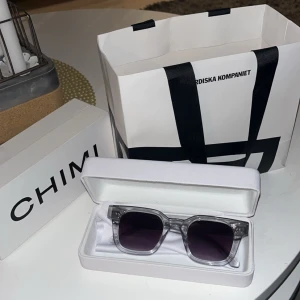 Transparenta solglasögon från Chimi - Snygga transparenta solglasögon från Chimi med fyrkantiga bågar och mörka linser. Perfekta för att ge en stilren touch till din outfit. Kommer i originalförpackning. Köptes i somras men använde dem bara ett par gånger. Pris kan diskuteras vid snabb affär!