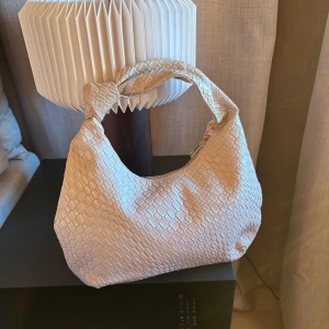 Flätad axelväska - Supersnygg beige flätad axelväska med ett jättesött knutformat handtag. Helt oanvänd, perfekt inför sommaren💕💕