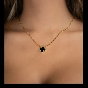 Guldhalsband med fyrklöverhänge - Elegant guldhalsband från Kejsar med ett svart fyrklöverformat hänge. Halsbandet är gjord i hållbart stål med 18K guldplätering. Aldrig använda då jag fick i guld när jag använder silver😊💗~nypris 1 199kr                                                         !Säljer även matchande armband! 