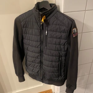 Svart cardigan jacka från Parajumpers - Säljer en svart cardigan från parajumper  väldigt stilren och lätt att dressa upp. Köpt för 3200 helt ny.Den har blivit lite solblekt men inte så mycket man tänker på. Skulle rekommendera jackan för nån som är runt 150-160  ja själv är 161 och sitter perfekt på mig nu. Pris går att diskutera,tveka inte på att höra av er😀