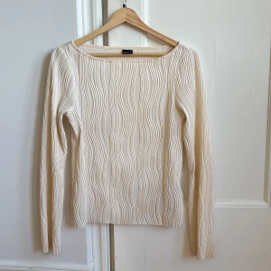 Beige långärmad topp från Gina Tricot - Säljer en stilren beige topp från Gina Tricot med långa ärmar och ett vågigt mönster. Toppen är i storlek S och har en mjuk och bekväm passform.