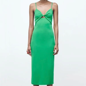 Grön klänning med cut-out från Zara - Snygg grön klänning från Zara med smala axelband och en trendig cut-out detalj framtill. Perfekt för en somrig look. Klänningen har en figurnära passform . Använd vid 2 tillfällen och är som ny