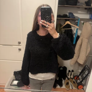 Svart fluffig tröja från Gina Tricot - Säljer en svart fluffig tröja från Gina Tricot. Tröjan har en mysig textur och långa ärmar, perfekt för kyligare dagar. Den är i storlek S och passar bra till både jeans och kjol.