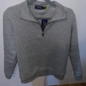 Ralph Lauren halv zip - Säljer en stilren grå tröja från Polo Ralph Lauren med halv dragkedja och broderad logga på bröstet. Tröjan är aldrig Andvänd lappen sitter kvar o sånt. Skick 10/10