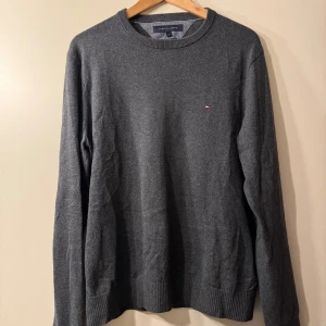 Grå tröja från Tommy Hilfiger - Grå tröja i bomull & kashmir blend (tror jag). Använd ett par gånger men inga skavanker. Är storlek S men passar som en M/L.