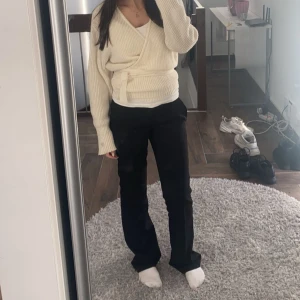 Vit omlott kofta - Säljer en stilren vit omlott kofta med knytband i midjan. Koftan är ribbad och har långa ärmar, perfekt för en mysig dag. Den är inte helt vit utan är en mer ton av beige. Skriv för fler bilder🫶🏻