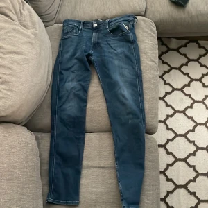 Mörkblå jeans replay - Snygga mörkblå jeansbyxor med en slim passform. De har klassiska fem fickor och en dragkedja med knappstängning. Perfekta för en stilren look.
